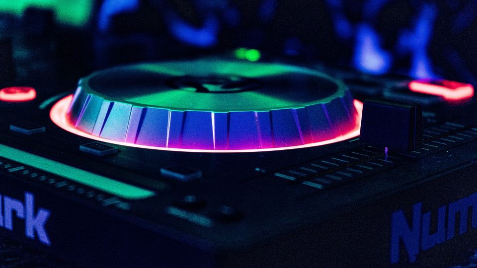 A DJ booth is lit with colorful backlights. 